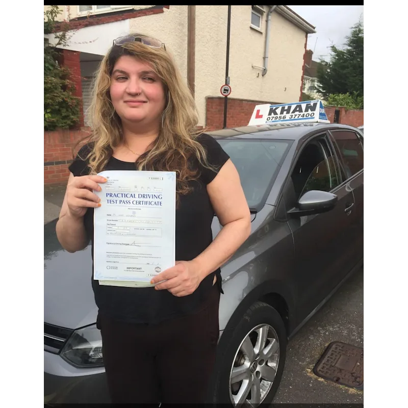 Happy pupil holding driving test pass certificate after lessons in Slough