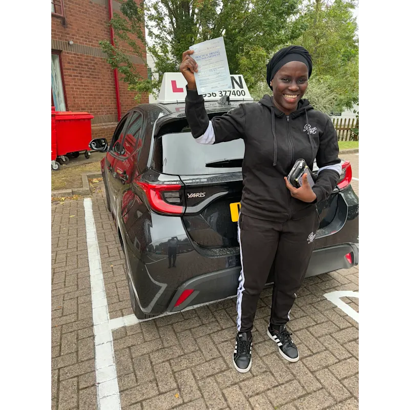 Happy pupil holding driving test pass certificate after lessons in Slough