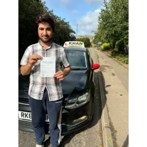 Happy pupil holding driving test pass certificate after lessons in Slough