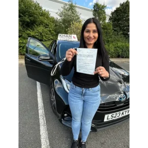 Happy pupil holding driving test pass certificate after lessons in Slough