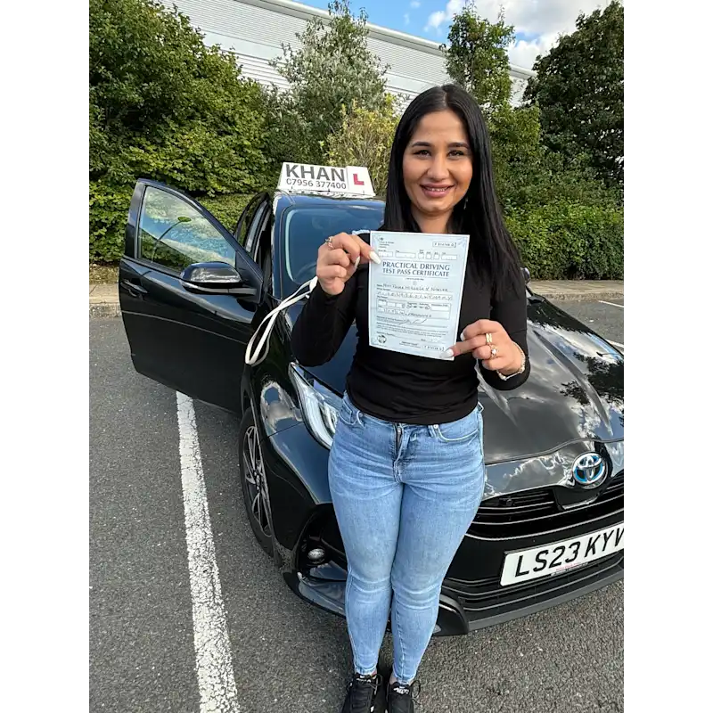 Happy pupil holding driving test pass certificate after lessons in Slough