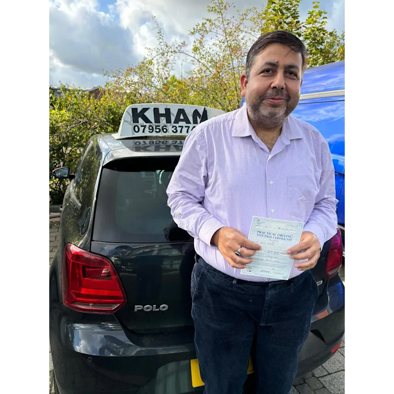 Happy pupil holding driving test pass certificate after lessons in Slough