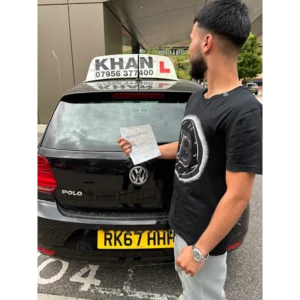 Happy pupil holding driving test pass certificate after lessons in Slough
