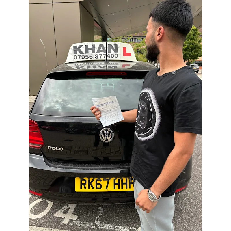 Happy pupil holding driving test pass certificate after lessons in Slough