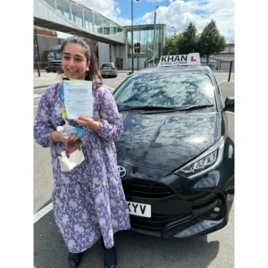 Happy pupil holding driving test pass certificate after lessons in Slough