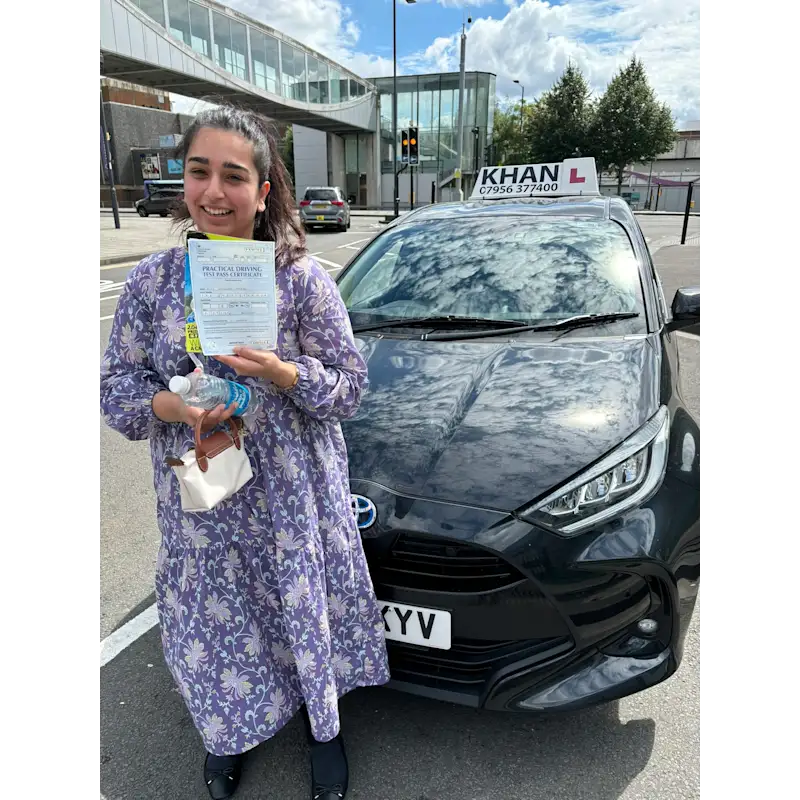 Happy pupil holding driving test pass certificate after lessons in Slough
