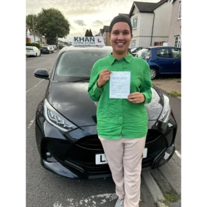 Happy pupil holding driving test pass certificate after lessons in Slough