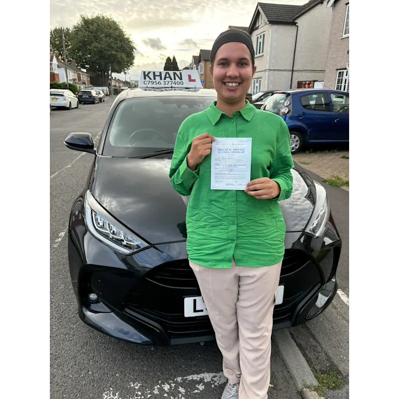 Happy pupil holding driving test pass certificate after lessons in Slough